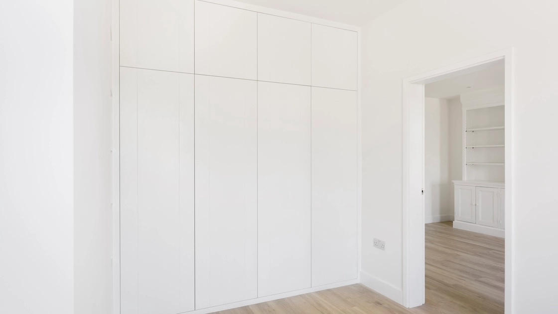 Minimalist white fitted wardrobes in room