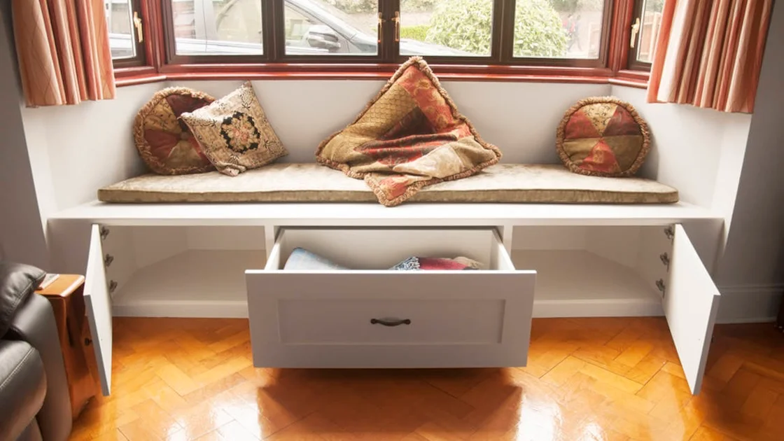 white window seat with open doors and a drawer