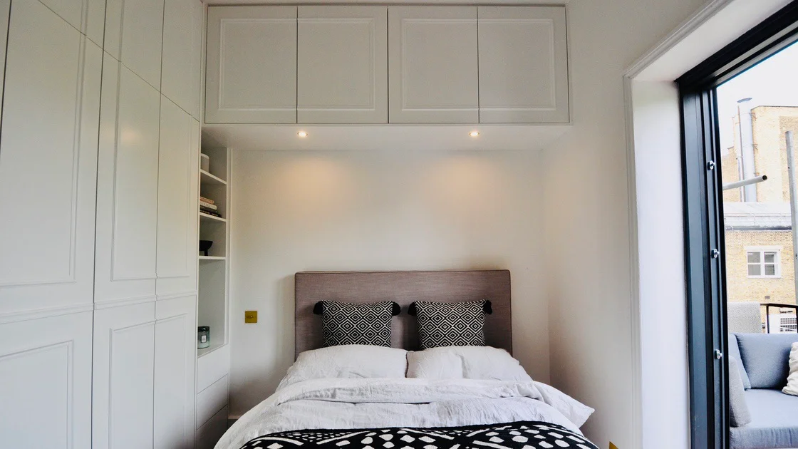bedroom wardrobe with cabiunets above bed