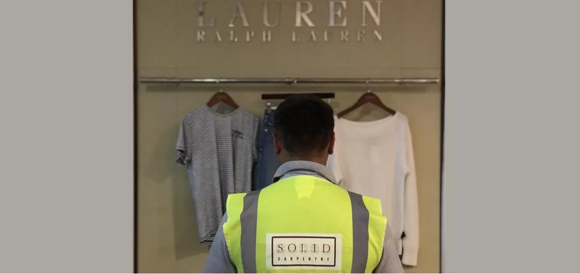 Solid Carpentry London worker in high-visibility vest shopping.